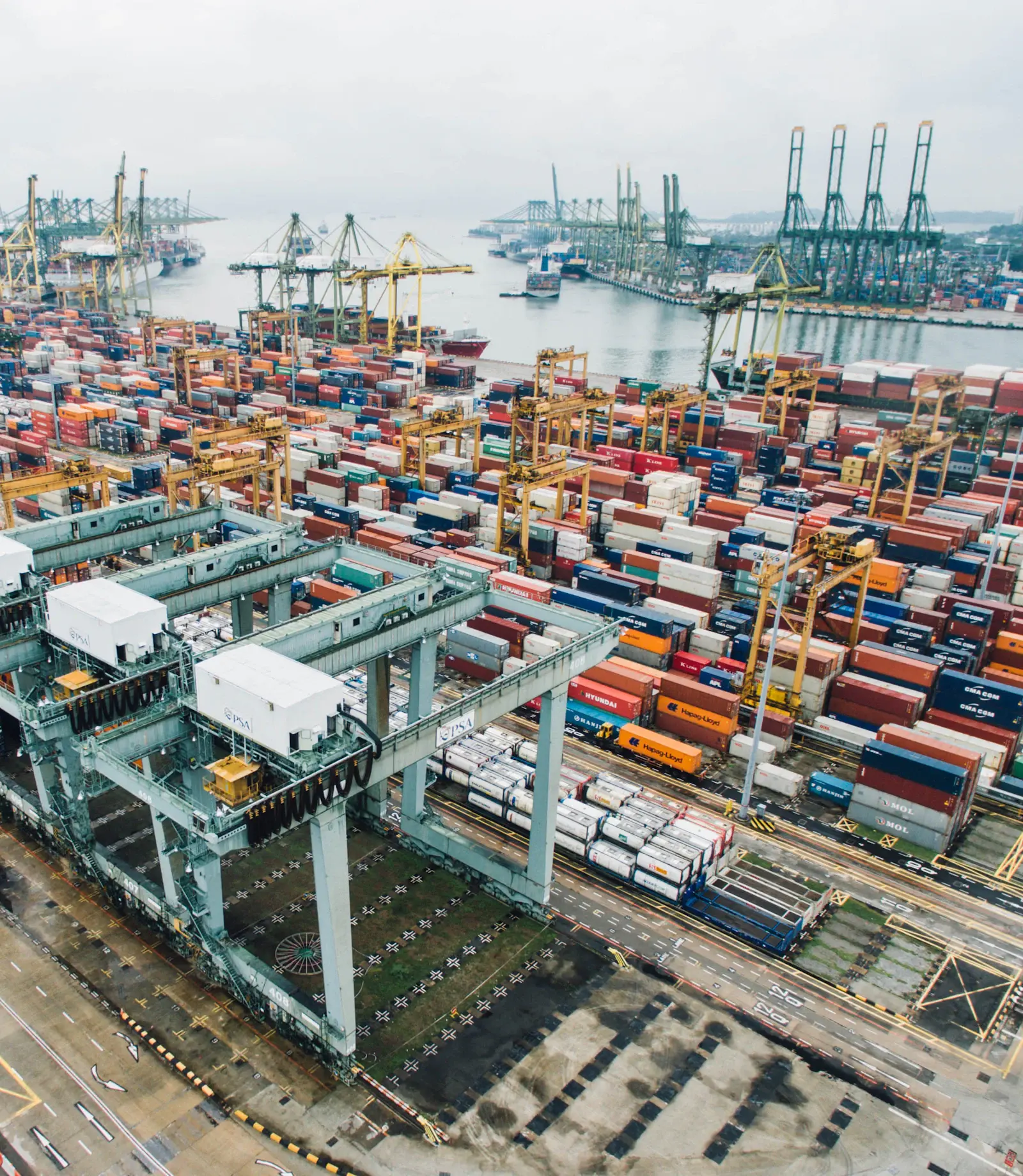 Aerial view of a container port with cranes and stacked shipping containers
